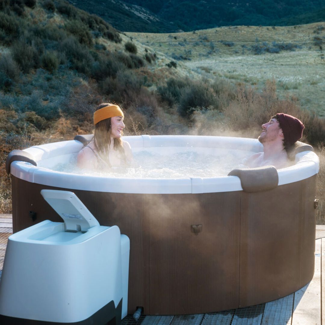 couple in an affordable hot tub surrounded by NZ nature - portablespasnz